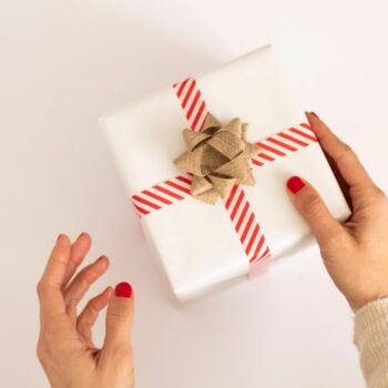 person holding white and red gift box