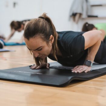 A group of people in a gym doing push ups