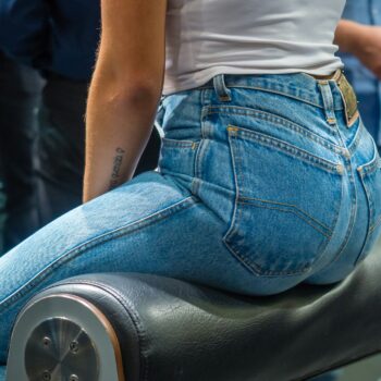woman sitting on black leather surface close-up photographyt