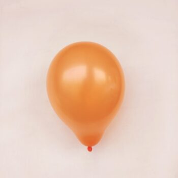 orange balloon on white surface