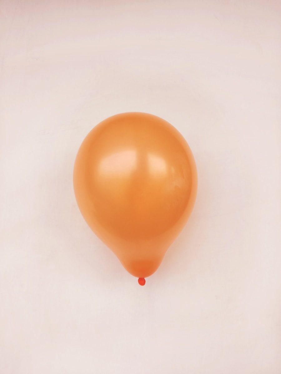 orange balloon on white surface