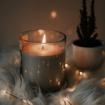 white candle on clear glass holder